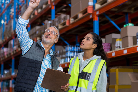 Manager is showing shelves to worker in a warehouseの写真素材