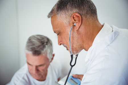 Doctor using stethoscope in a retirement homeの写真素材