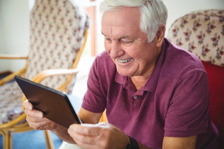Senior man using a digital tablet in a retirement homeの写真素材