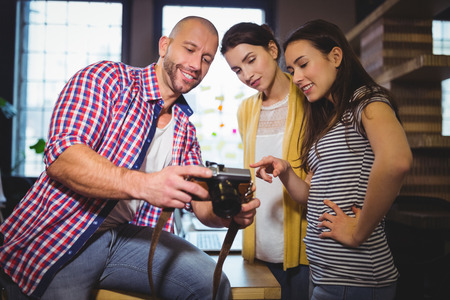 Business people smiling while looking at camera in creative officeの写真素材