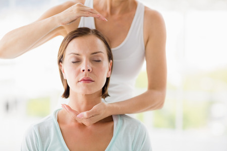 Woman receiving massage treatment from masseur at homeの写真素材
