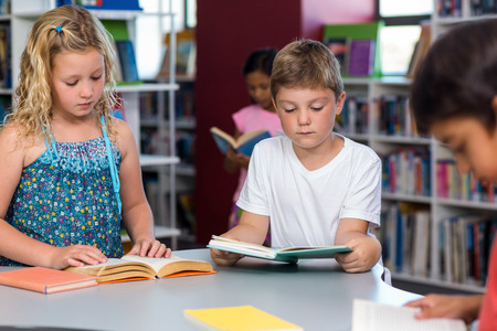 Children reading books in libraryの写真素材