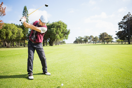 Golfer raising his golf club before his shotの写真素材