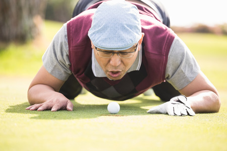 Golfer blowing ball in the hole on the golf courseの写真素材