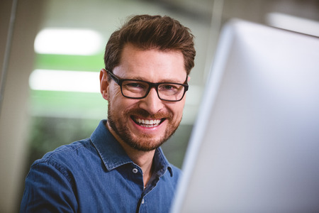 Portrait of cheerful young businessman at creative officeの写真素材