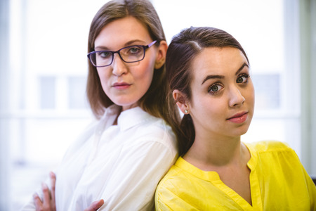 Portrait of confident young female executives standing at creative officeの写真素材