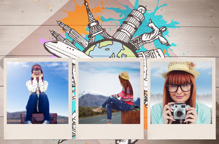 Smiling hipster woman sitting on suitcase  against colored woodの写真素材