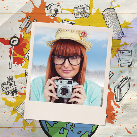 Portrait of a smiling hipster woman holding retro camera against colored woodの写真素材