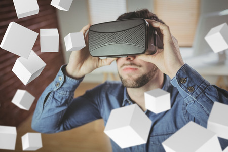 Digitally generated grey cubes floating  against man wearing virtual glass