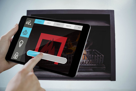 Man using tablet pc against fireplace set in wall