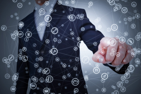 Smiling businessman in suit pointing  against grey background