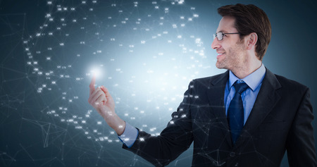 Smiling businessman pointing at a copy space against grey vignetteの写真素材