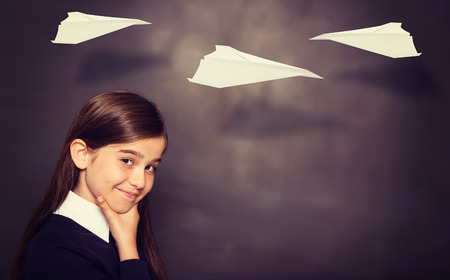 Paper airplane graphic against thinking pupil looking at camera