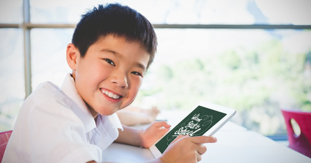 Image of a chalkboard    against smiling boy holding digital tablet