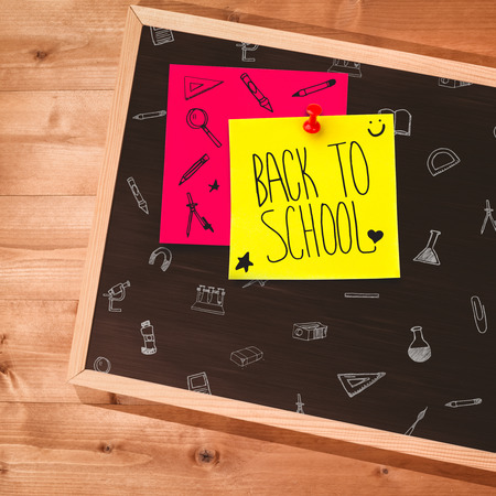 Back to school message against small blackboard on wooden floor