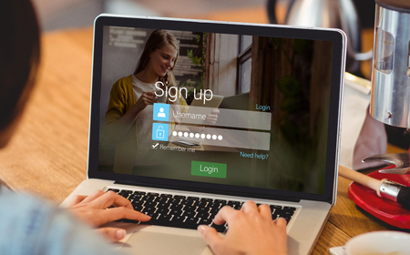 signup screen with blonde girl and pad against woman using laptop at officeの写真素材