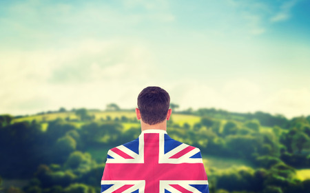 Businessman looking in front of him in suit against digitally generated uk national flagの写真素材