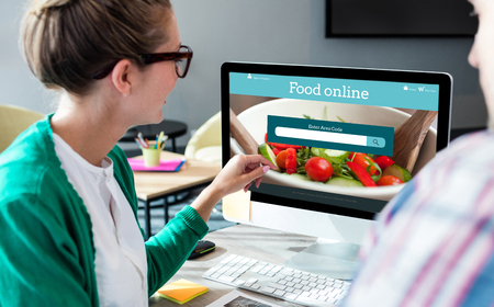 Food app against business people discussing over computer monitorの写真素材