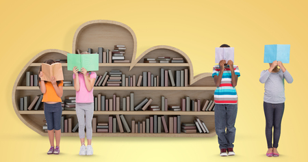 Elementary pupils reading against yellow vignetteの写真素材