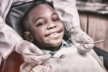 Close up of boy having his teeth examined by a dentistの写真素材