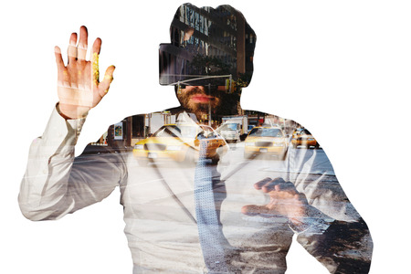 businessman with virtual reality glasses at desk against new york streetの写真素材