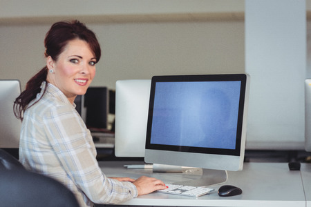 Portrait of mature student using computer in the computer room at college