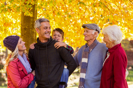 Happy multi-generation family standing at park during autumnの写真素材