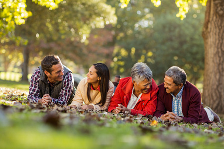 Joyful family lying on front against trees at park