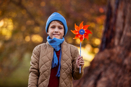 Portrait of smiling boy holding pinwheel while standing at parkの写真素材