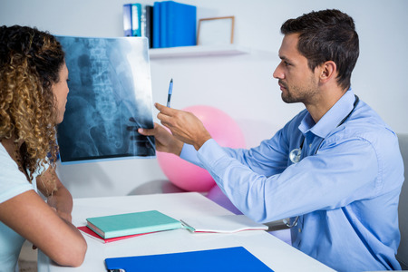 Physiotherapist explaining x-ray to patient in clinicの写真素材