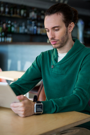 Man using digital tablet in coffee shopの写真素材