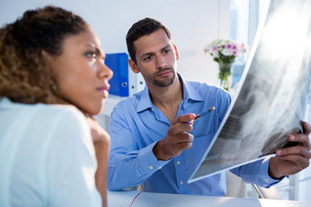 Physiotherapist explaining x-ray to patient in clinic