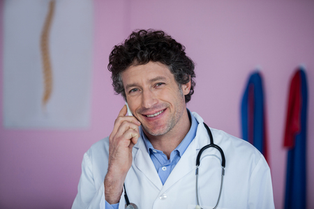 Portrait of physiotherapist talking on mobile phone in clinicの写真素材