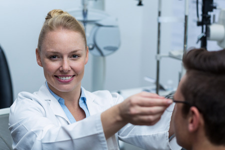 Female optometrist prescribing spectacles to patient in ophthalmology clinicの写真素材