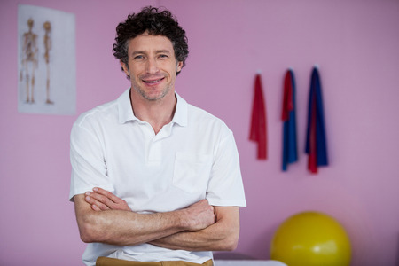 Portrait of physiotherapist standing with arms crossed in clinicの写真素材