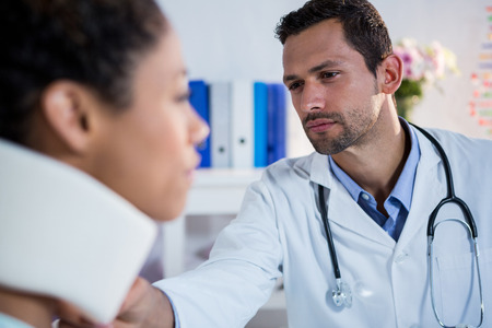 Physiotherapist examining a female patients neck in clinicの写真素材