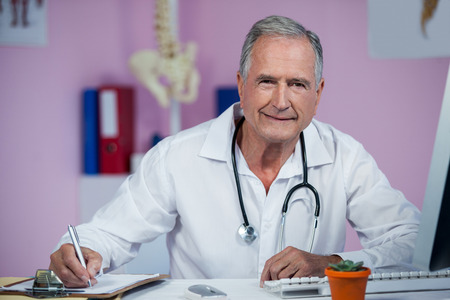 Physiotherapist writing on clipboard in clinicの写真素材