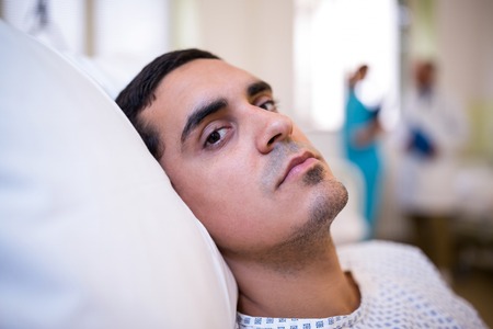 Close-up of patient lying on bed in hospitalの写真素材