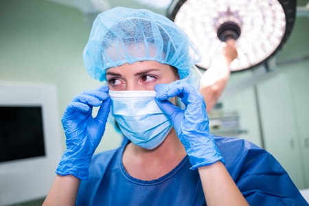 Female surgeon wearing surgical mask in operation room at hospital