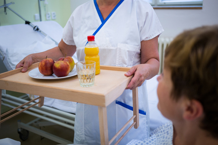 Nurse serving a breakfast to patient in hospitalの写真素材