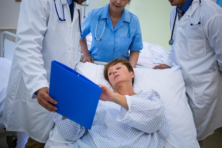 Doctors showing medical report to patient in hospitalの写真素材