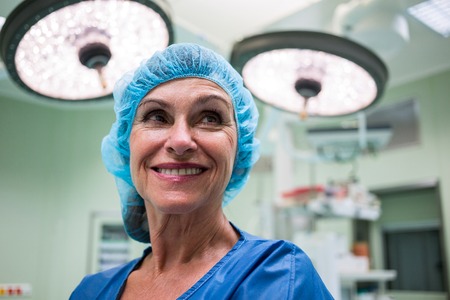 Smiling surgeon standing in operation room at hospitalの写真素材