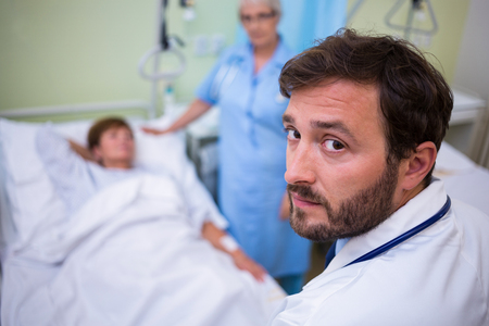 Portrait of doctor standing in hospital roomの写真素材
