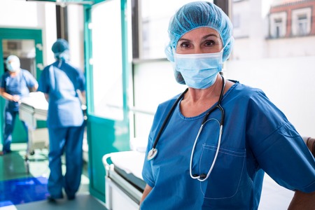 Portrait of surgeon standing in corridor at hospitalの写真素材