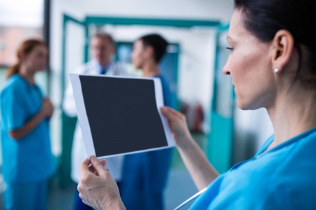 Surgeon examining a report in hospitalの写真素材