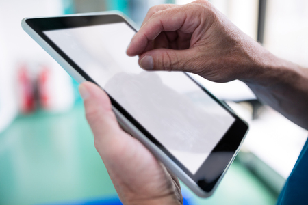 Surgeon using digital tablet in hospital corridorの写真素材