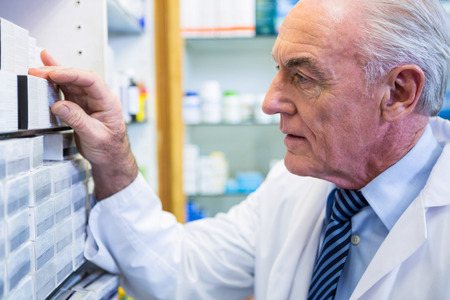 Pharmacist checking medicines in pharmacyの写真素材