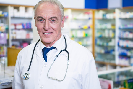 Portrait of pharmacist in lab coat at pharmacyの写真素材