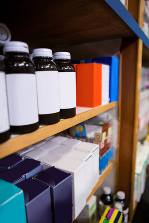 Various boxes and bottles of medicine on shelf in pharmacyの写真素材