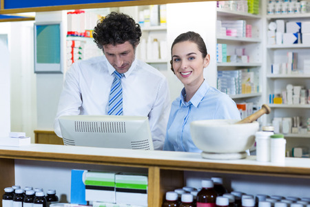 Pharmacists working at counter in pharmacyの写真素材
